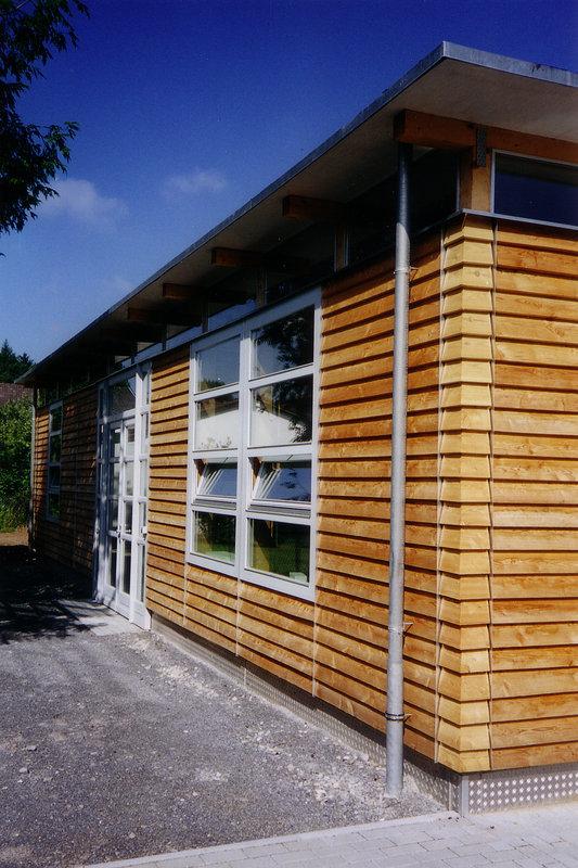 Fenster in weiß in Haus mit Holzfassade