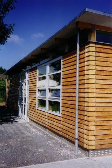 Fenster in weiß in Haus mit Holzfassade